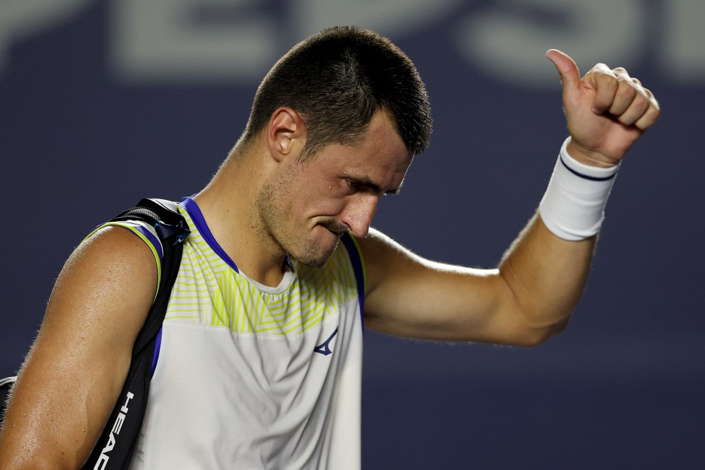 Bernard Tomic of Australia gives a thumbs-up after losing his tennis match.