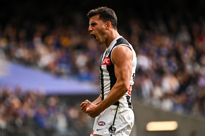 Nick Daicos pumps his fists and yells after kicking a goal against West Coast.