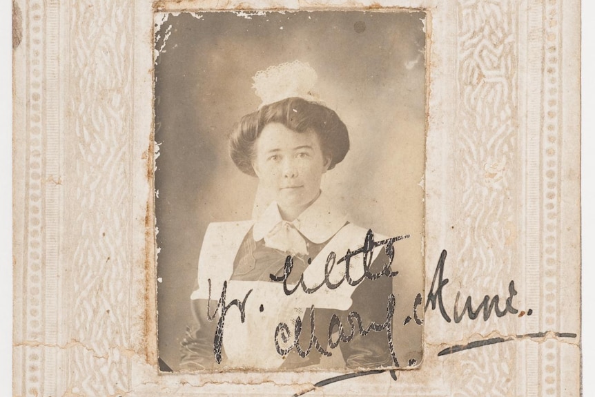 A black and white photo of a woman in the 1900s, dressed as a maid.