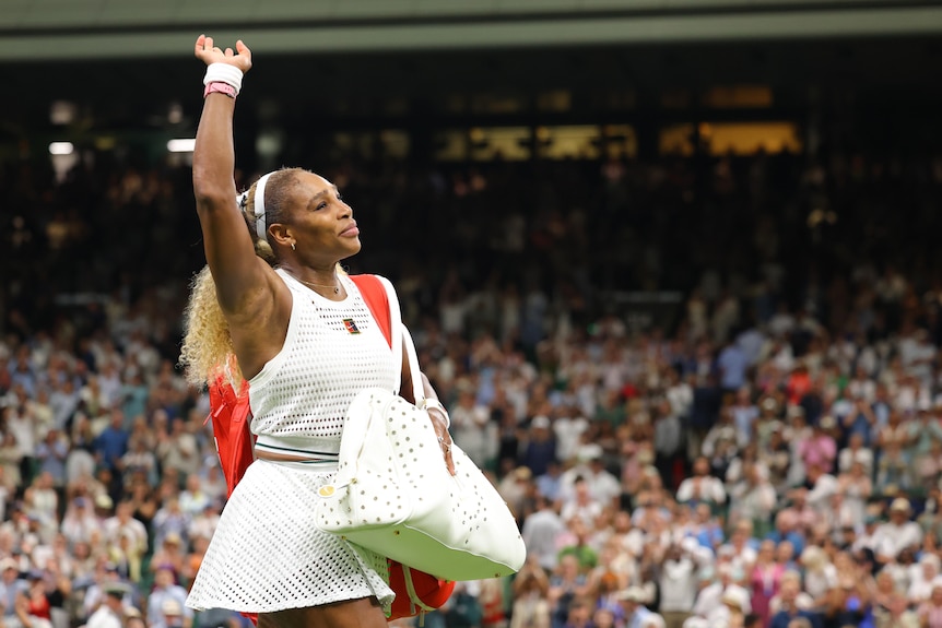 Serena Williams waves to the Wimbledon crowd as she leaves the court.