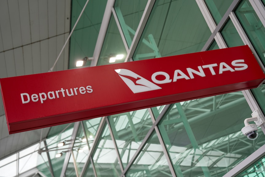 A Qantas sign with the word 'departures' on it.