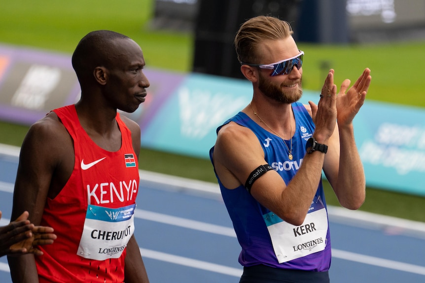 A young athlete applauds the crowd in a stadium