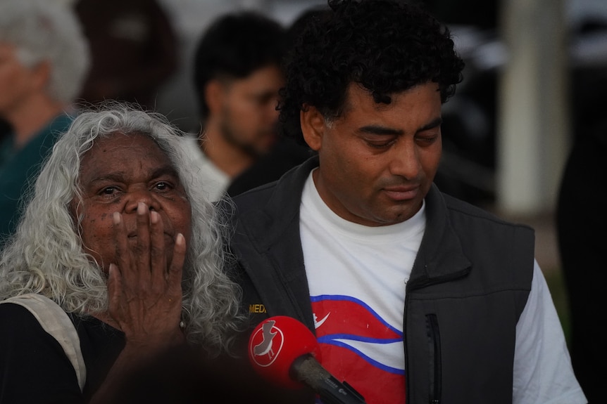 An older, white-haired woman and a middle-aged, dark-haired man at a community gathering.
