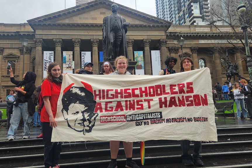 Students holding up a banner protesting Pauline Hanson
