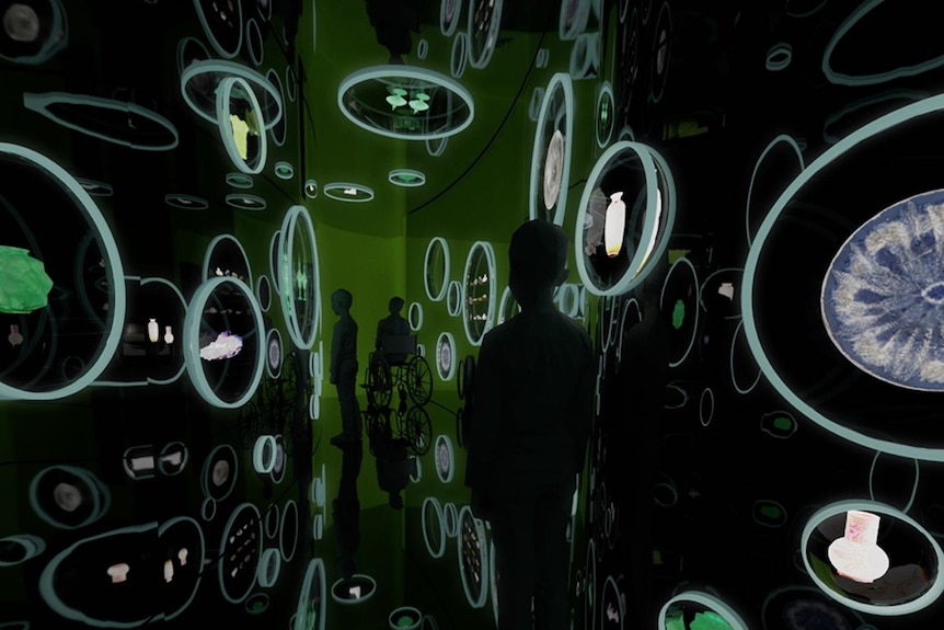 A person stands inside a darkened room that features fluorescent light designs