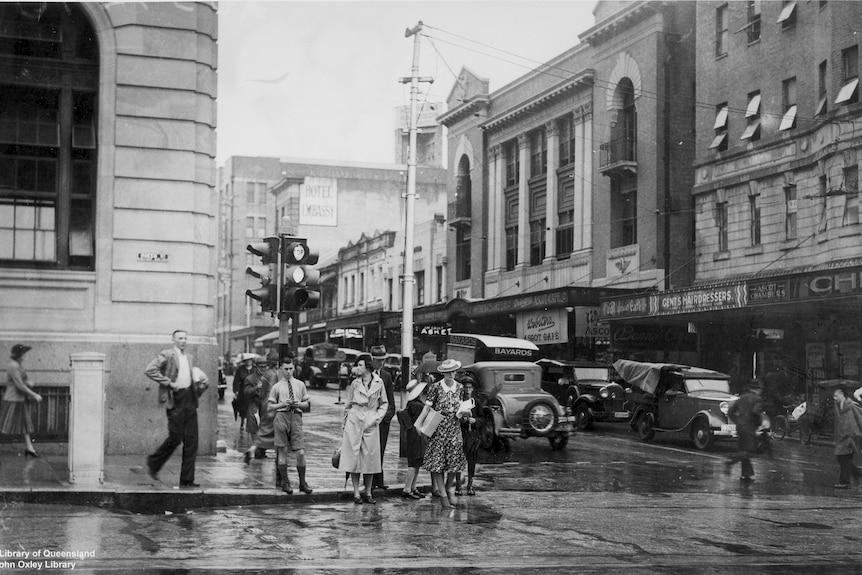 A black and white photo of pedestrians and cars in Brisbane's CBD in 1940.