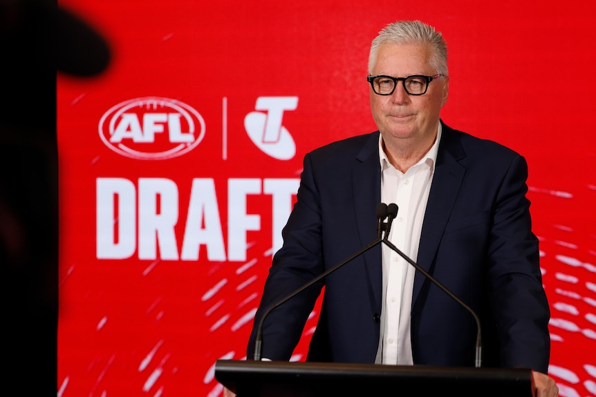 Greg Swann stands in front of a draft sign