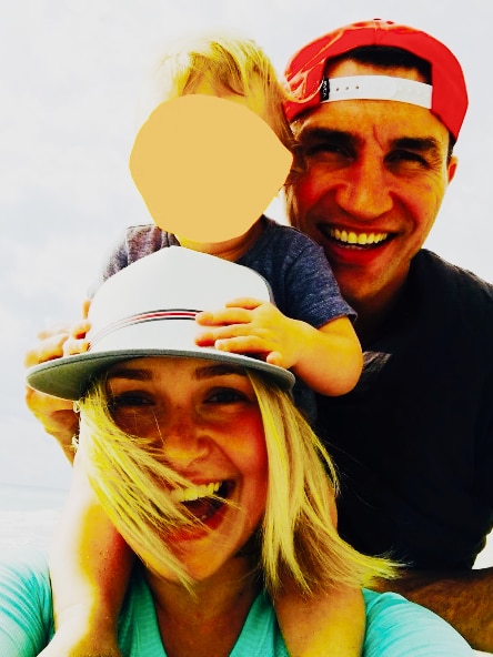 A family photo of a man, woman and children who is blurred.