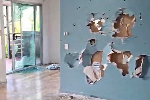 smashed walls and windows inside waterfront house