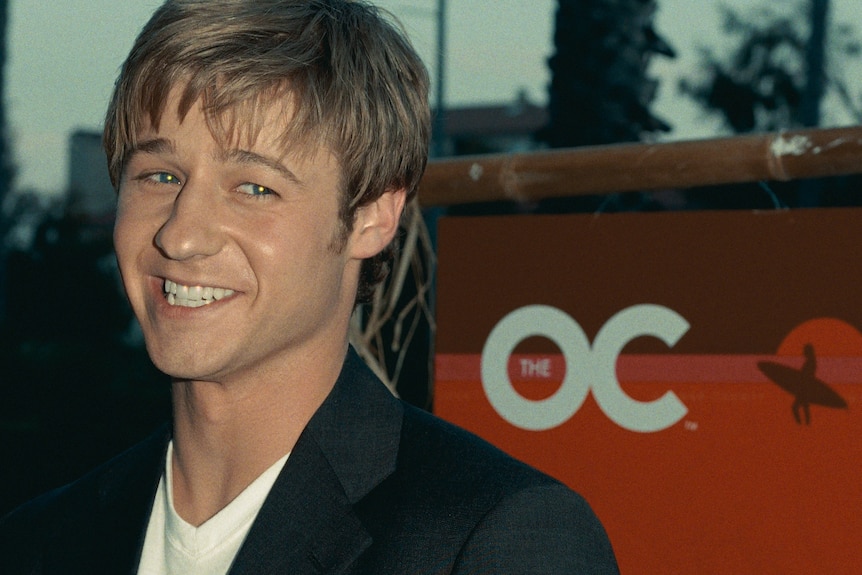 Ben McKenzie on the red carpet, smiling.