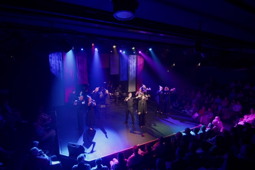 A view from above of performers on stage under lights.