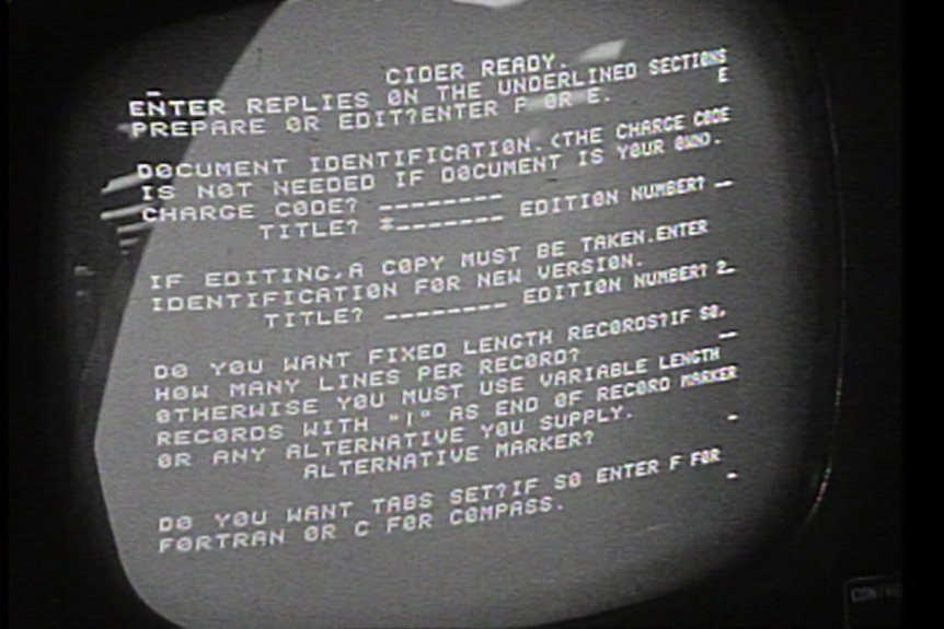 White text on a black computer screen showing words and code in the 1960s