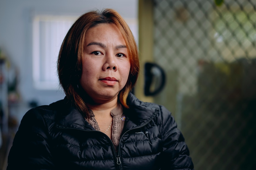 Vietnamese woman with bob haircut in puffer jacket looking at camera