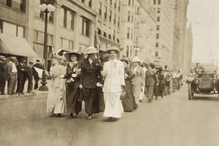 A black and white photo from 1912 of a group of women marching on a Chicago street.