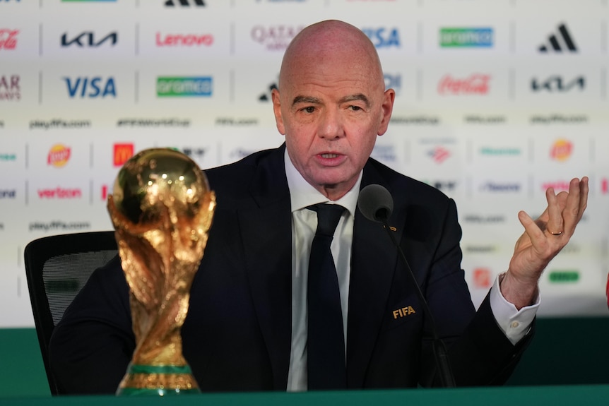 FIFA President Gianni Infantino speaks during a news conference with the World Cup trophy beside him.
