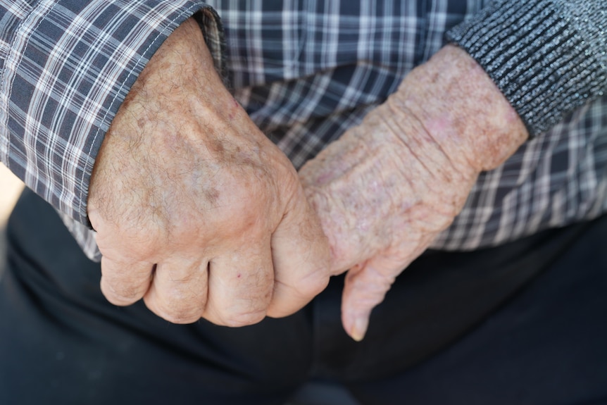A close up and older people holding hands