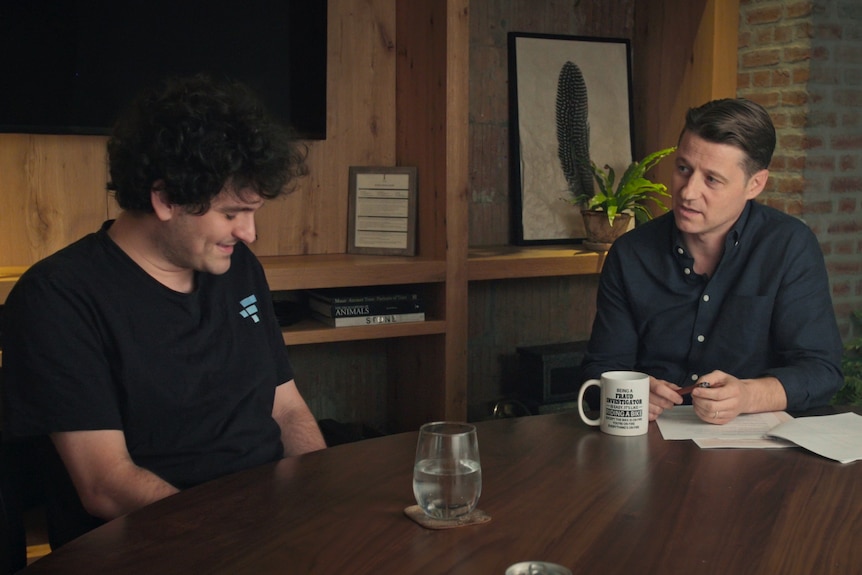Ben McKenzie sitting at a table with Sam Bankman-Fried.