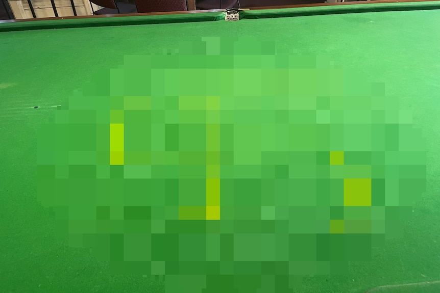 A blurred photo of a swastika on a billiard table.