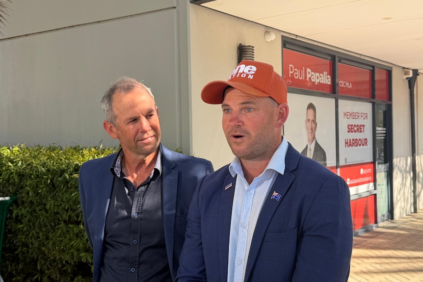 Two man in suit speak to press outside Paul Papalia's office.