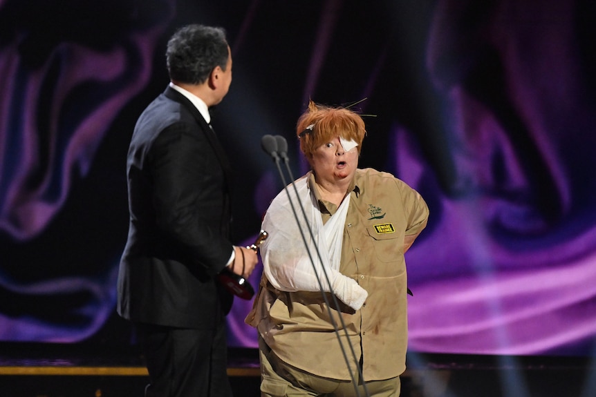 Sam Pang looks at Magda Szubanski, who is bandaged up and wearing an Australia Zoo uniform.