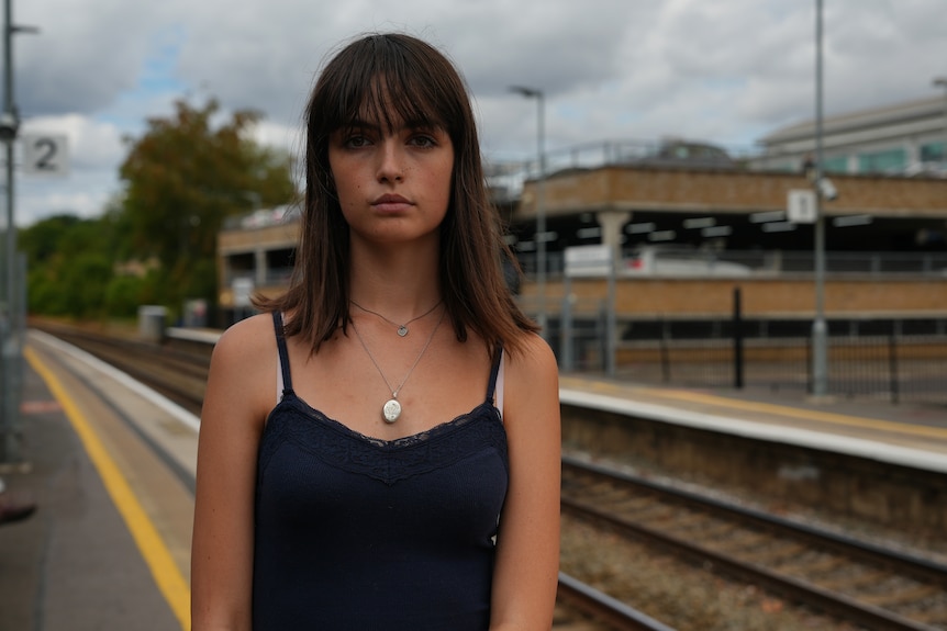 A woman standing at a train station.