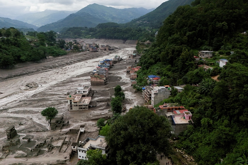 An aerial photo of mud covering houses and vehicles.