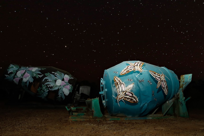 A nighttime photo of a mining agitator shows large softly-winged moths