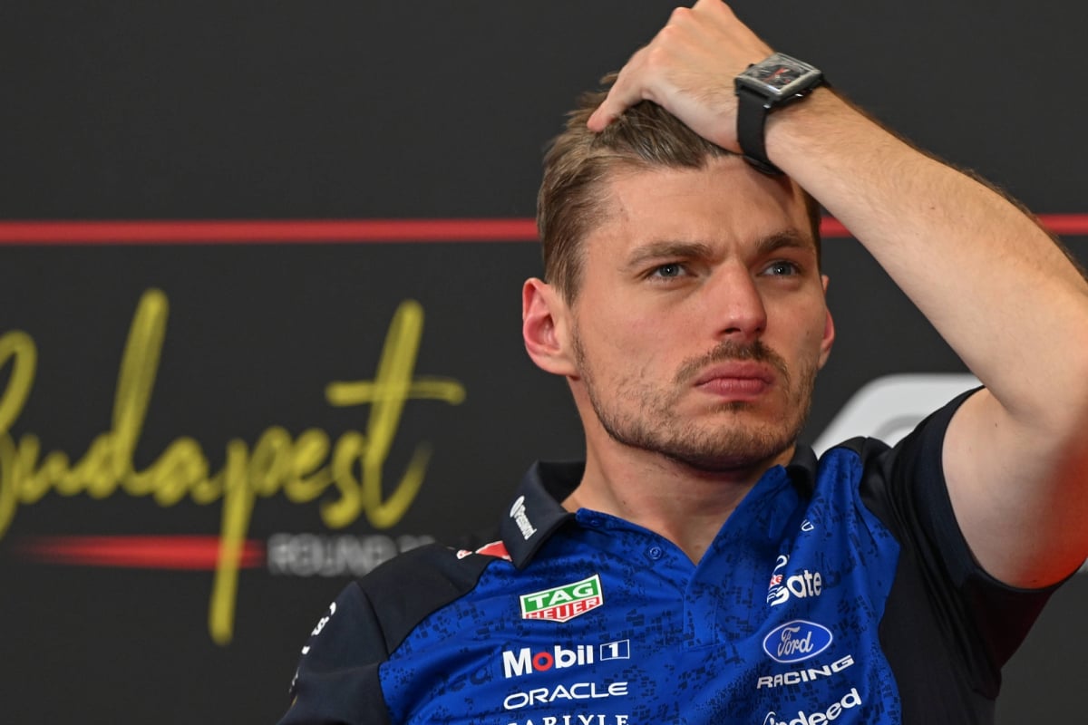 Verstappen on FIA sofa in Red Bull kit looking stressed with hand running through hair
