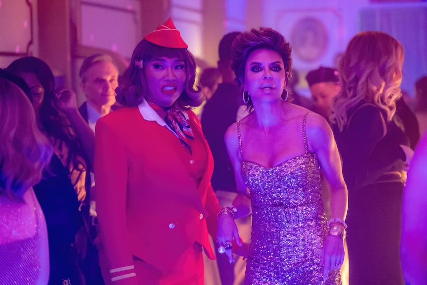 Two women stand in a party
