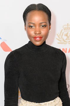 A young woman dressed in a black polo neck.