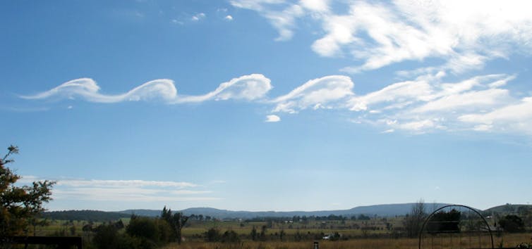 A scalloped cloud in a blue sky.