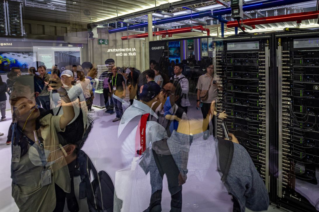 The reflection of attendees is seen on a glass window showcasing GIGABYTE server racks at a booth during COMPUTEX on June 02, 2026 in Taipei, Taiwan.