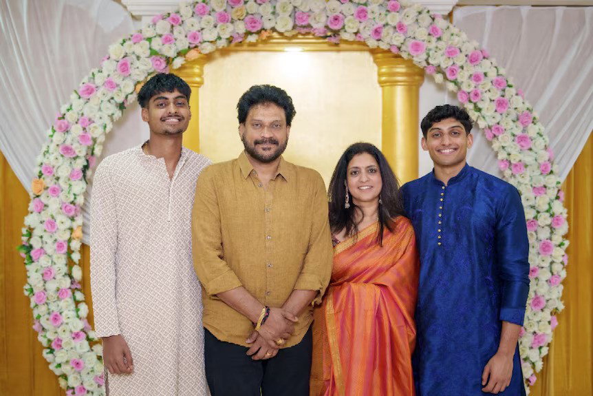 A family of four, husband and wife and two sons in their 20s - all in formal attire.