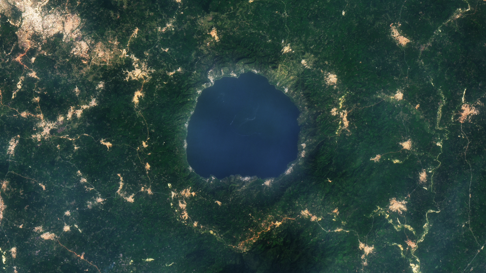 A 2015 satellite photo showing a series of golden tendrils surrounding a round blue lake