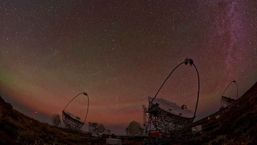 The LST-1 and MAGIC telescopes on La Palma stand in the darkness beneath a clear, star-studded night sky.