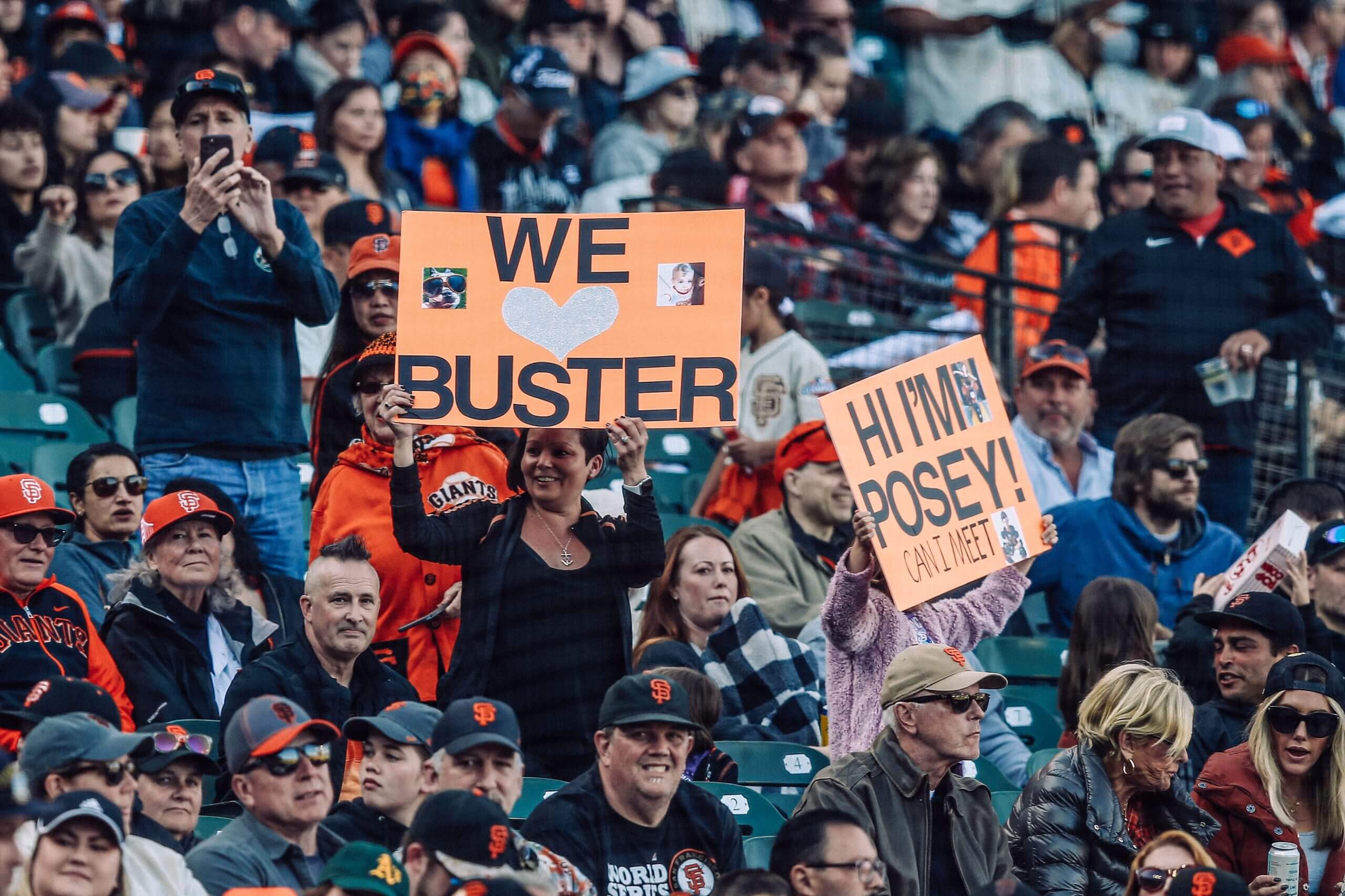 Giants fans hold signs in support of team president Buster Posey