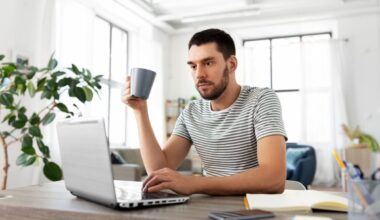 A young investor is sitting at a desk using a laptop.