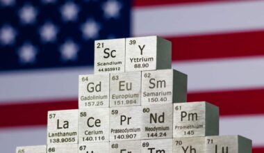 Cubes representing rare earth elements in front of a US flag.