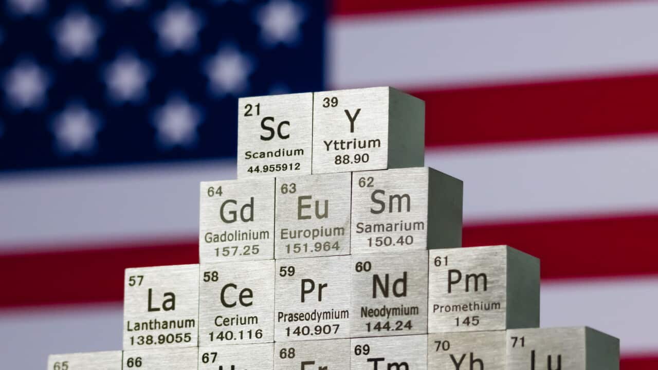Cubes representing rare earth elements in front of a US flag.