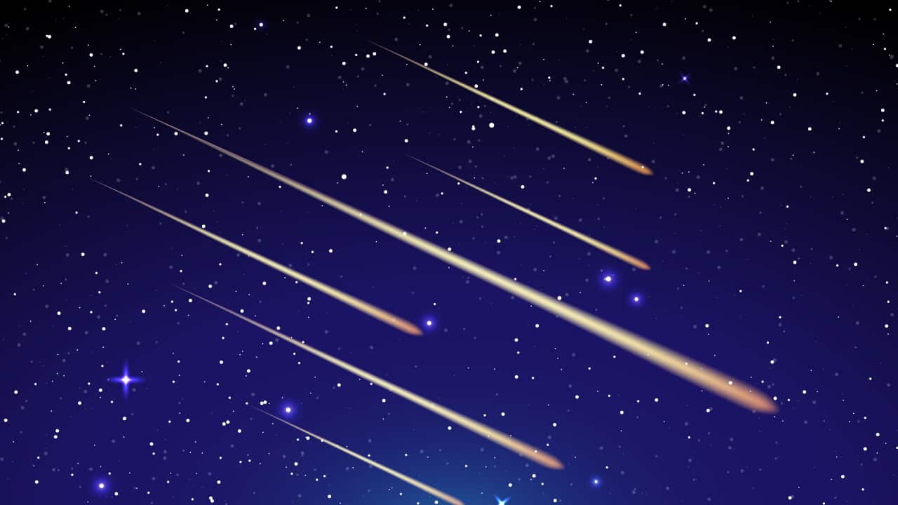 A group of meteorites shooting in a blue sky.