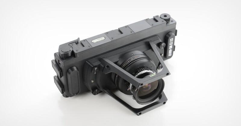 A black, rectangular panoramic film camera with a wide-angle lens and a metal frame mounted on the front, shown against a plain white background.