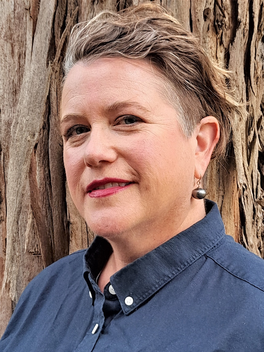 A woman with short hair and wearing a blue shirt