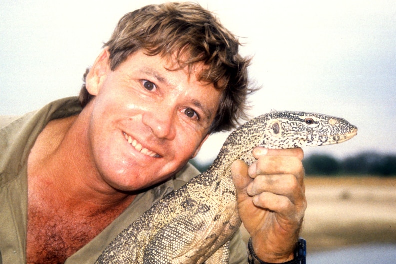 Man smiling holding a goanna