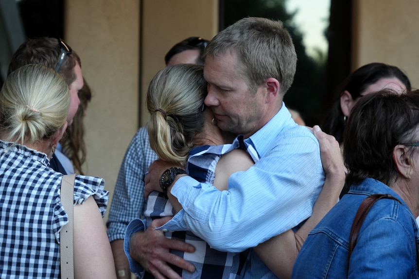 A group of people gathering and hugging. 