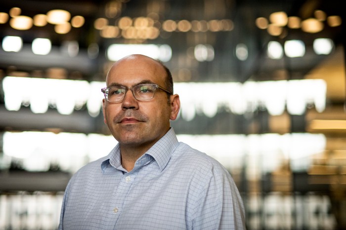 Portrait of Peelle with a blurred background of a modern building. 