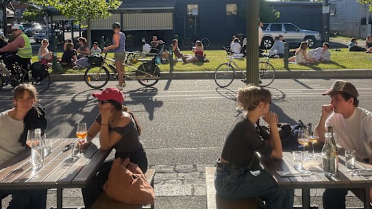 Patrons at the Wine Corner Store and on the nature strip on Canning Street in Carlton North.