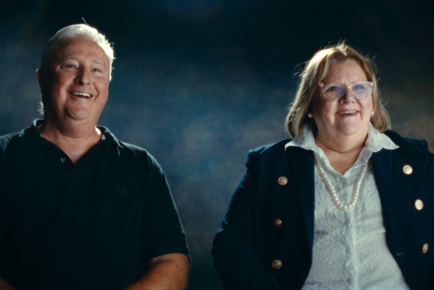An older couple both looking animated, relaxed and happy, man balding, woman blonde