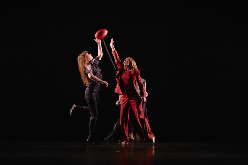 On stage two women compete for an AFLW ball up.