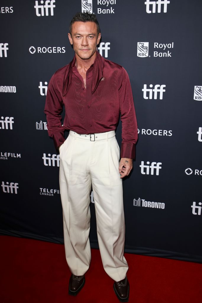 Luke Evans posing on the red carpet at "The Housewife" world premiere.