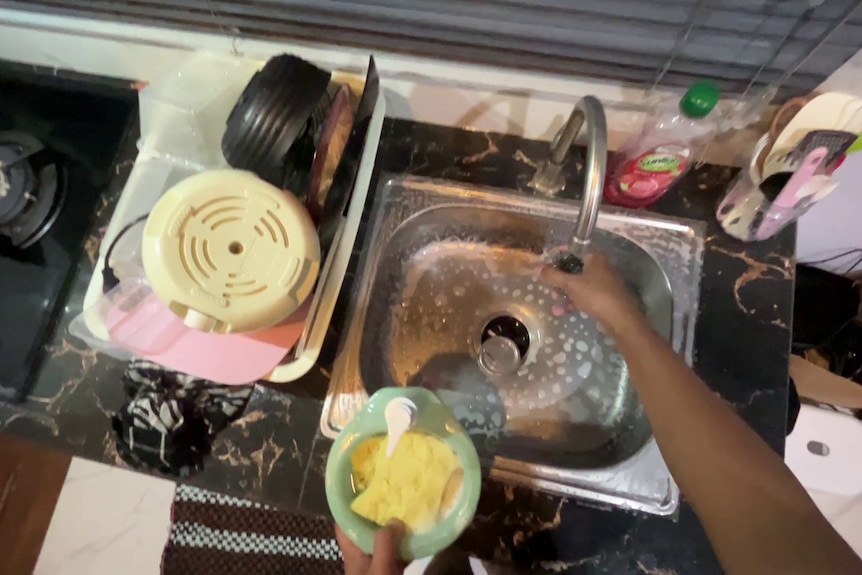 A still from a first-person perspective video cleaning a sink.